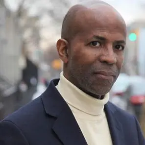 A man in a suit and tie standing outside.