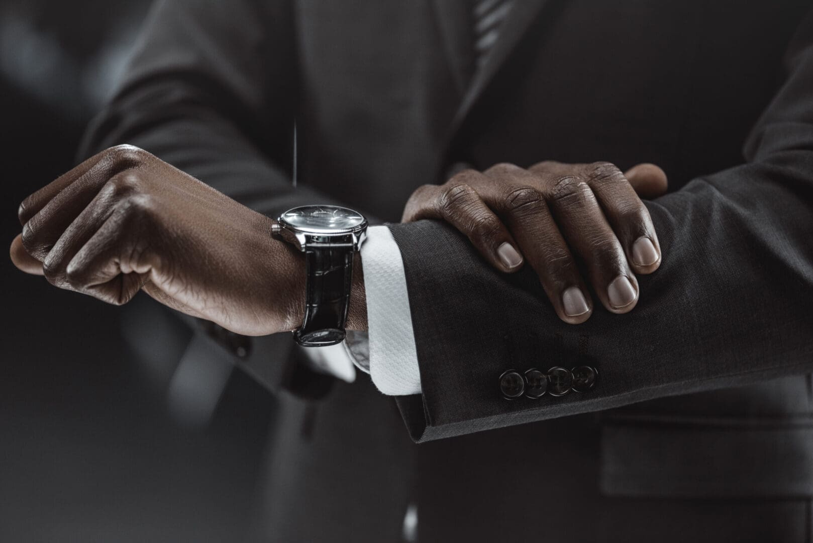 A person wearing a watch and holding a laptop