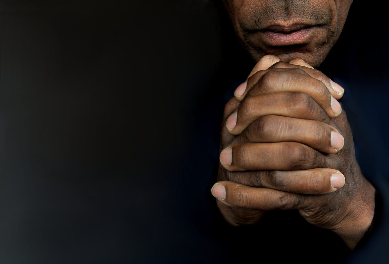 A man with his hands folded in prayer.