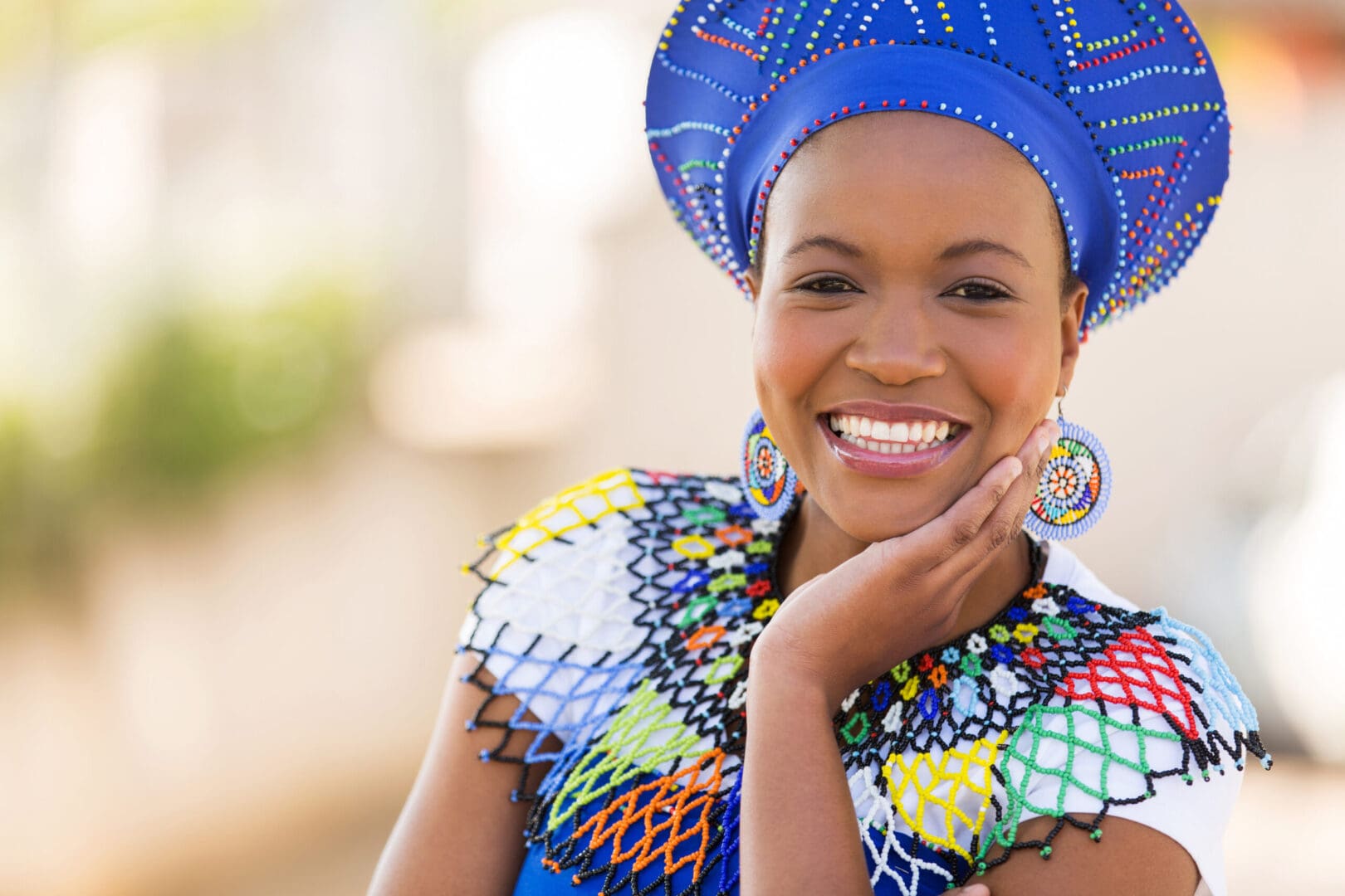 A woman in traditional african clothing smiling for the camera.