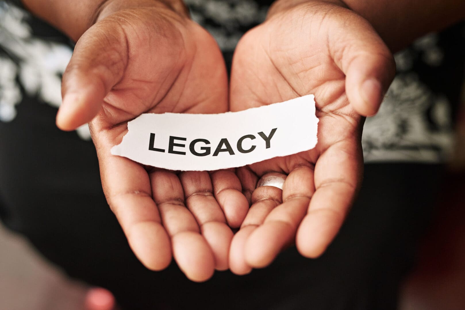 A person holding out their hands with the word legacy on it.