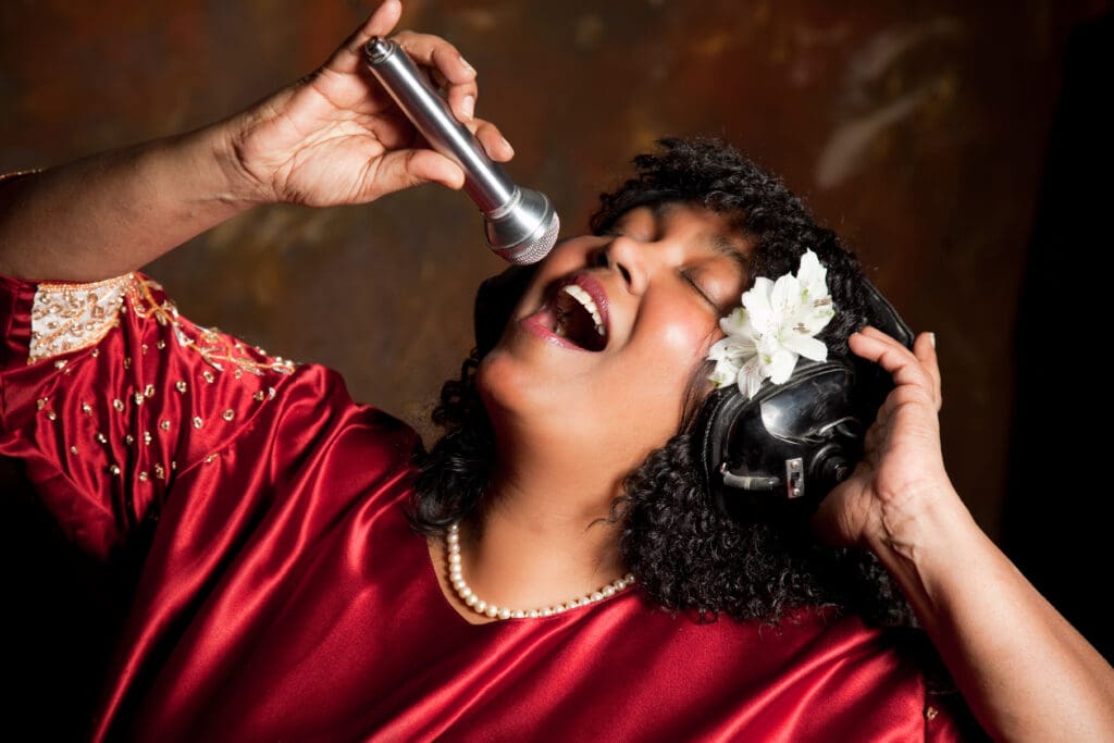 image of a black lady singing on a mike