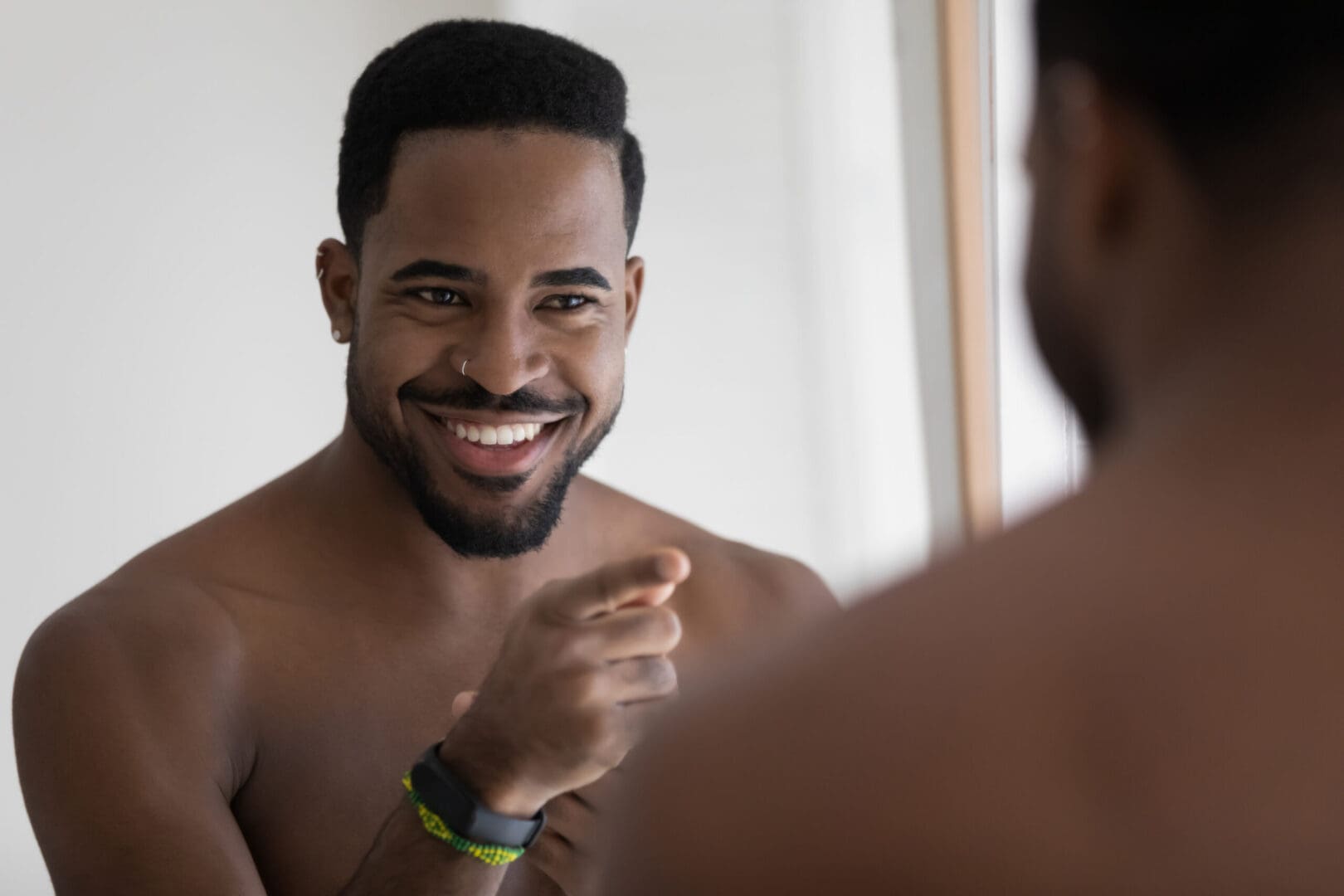 A man is looking at his teeth in the mirror.