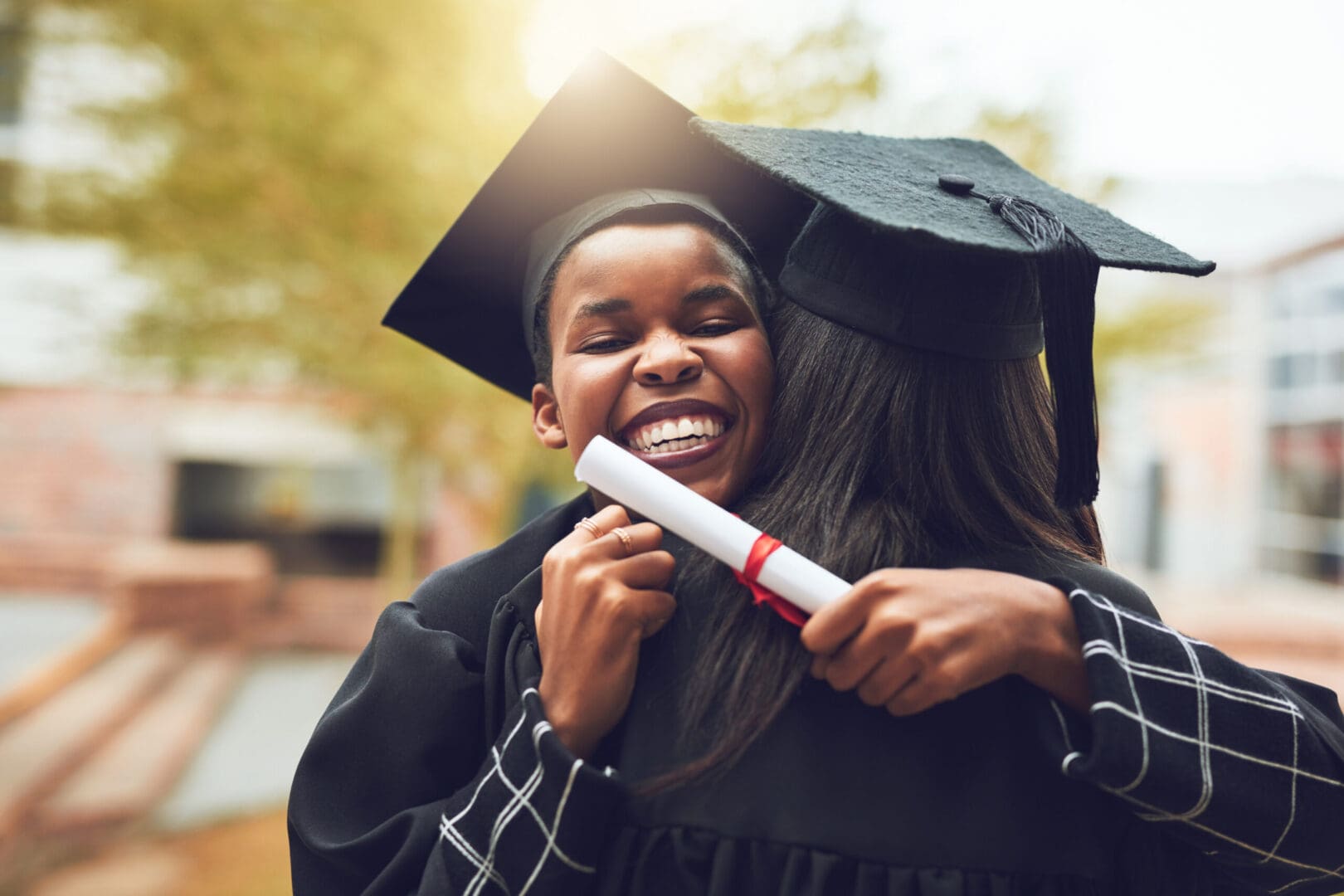 A woman in graduation gown holding a diploma.