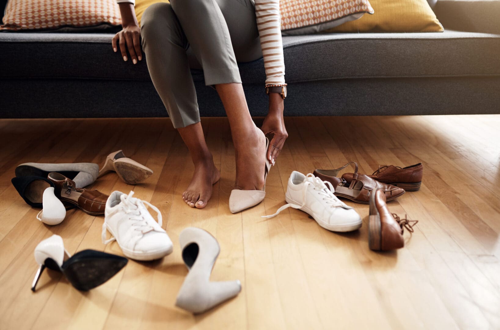 A woman sitting on the floor with her shoes.