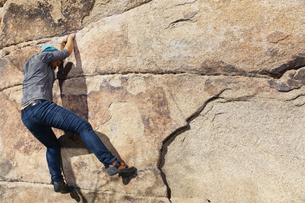 A man is climbing on the side of a rock