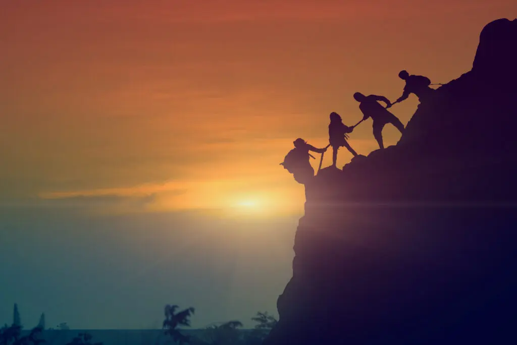 A group of people climbing up the side of a mountain.