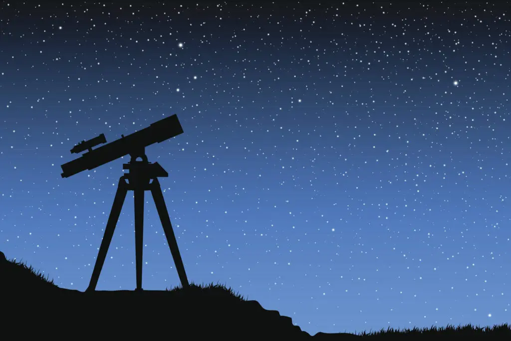 A telescope on top of a hill under the stars.