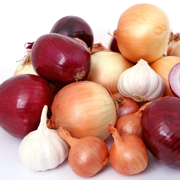 A pile of onions and garlic on top of each other.