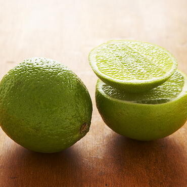 A close up of two limes on a table