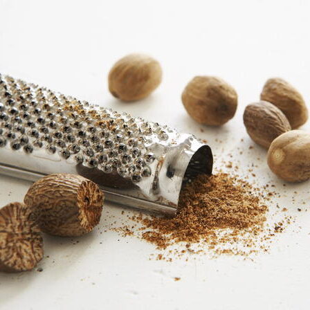 A grater with some nuts on it