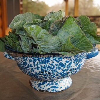 A bowl of green leaves on top of a table.