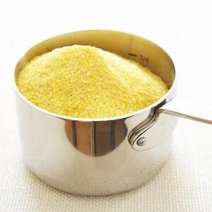 A metal pot filled with yellow powder on top of a table.